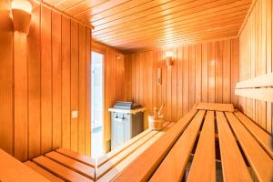 a wooden sauna with a bench in the middle at Airways Hotels Frankfurt Airport West in Raunheim