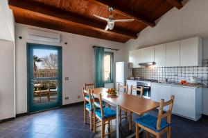 a kitchen with a wooden table and chairs and a dining room at Case Malavilla in Santa Croce Camerina