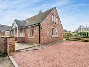 a brick house with a driveway in front of it at 4 Bed in Crosby-on-Eden 94398 in Crosby