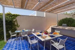 eine Terrasse mit einem Tisch und Stühlen mit Obst darauf in der Unterkunft Ferienhaus in Ragusa mit Möblierter Terrasse in Marina di Ragusa