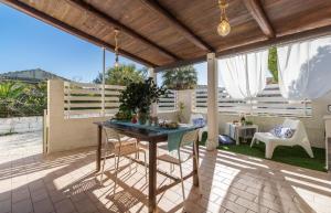 eine Terrasse mit einem Tisch und Stühlen darauf in der Unterkunft Edoné, Wohnung mit Blick auf einen Sandstrand in Santa Maria Del Focallo