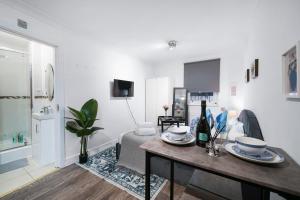a white living room with a table and a couch at Livestay Affordable Studio/1Bed Apartments in E14 in London