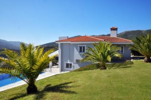 una casa con palmeras frente a un patio en Villa Raks, en La Canea