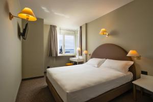 a bedroom with a large white bed and a window at Hotel Nettuno in Bardolino +40 photos