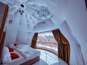 Zimmer mit einem Bett in einem Zelt mit einem Fenster in der Unterkunft Rum Crystal Luxury Camp in Wadi Rum