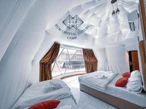 Zimmer mit 2 Betten in einem weißen Zelt in der Unterkunft Rum Crystal Luxury Camp in Wadi Rum