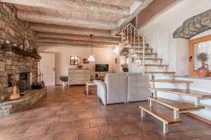 a living room with a staircase and a stone fireplace at Pool Villa Lavanda in Šmarje