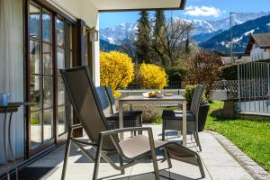 d'une terrasse avec une table, des chaises et des montagnes. dans l'établissement Olympia-Residence, à Garmisch-Partenkirchen
