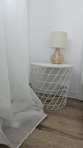 a end table with a lamp on top of it at Home and Travel 1BDR Apartment in Timişoara