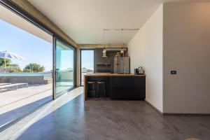 a kitchen with a counter and a large window at Demetra, moderne Villa mit Pool und Meerblick in Marina di Ragusa