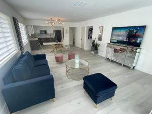 a living room with a blue couch and a tv at Pinto luxury Village in Hallandale Beach