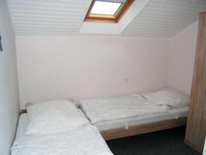 ein kleines Schlafzimmer mit einem Bett und einem Dachfenster in der Unterkunft "Friesenhörn" 31 Merchant in Horumersiel