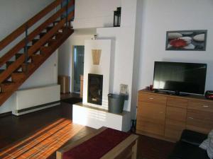 ein Wohnzimmer mit einem TV und einer Treppe in der Unterkunft "Friesenhörn" 31 Merchant in Horumersiel