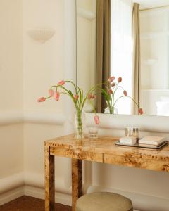einen Holztisch mit einer Blumenvase darauf in der Unterkunft LILOU in Hyères