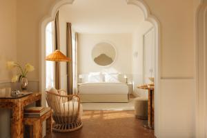 Un dormitorio con una cama y una mesa con una silla. en LILOU, en Hyères