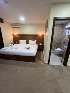 a bedroom with a large bed and a bathroom at Petra Aretas Hotel in Wadi Musa