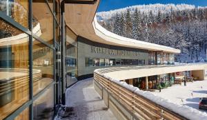 ein Bahnhof mit Schnee auf dem Boden und ein Gebäude in der Unterkunft Forsthaus Apartment in Holzschlag