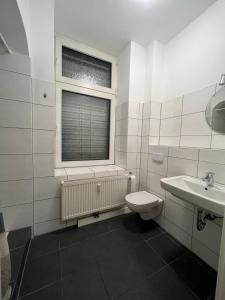 La salle de bains est pourvue de toilettes, d'un lavabo et d'une fenêtre. dans l'établissement Delta Haus, à Gelsenkirchen