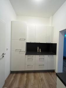 una cucina con armadietti bianchi e pavimenti in legno di Delta Haus a Gelsenkirchen