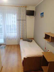 um pequeno quarto com uma cama e uma janela em Za Burtą em Jastrzebia Gora