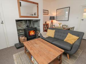 a living room with a couch and a fireplace at Lavender Cottage in Alnwick