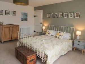a bedroom with a bed with a white bedspread at Lavender Cottage in Alnwick