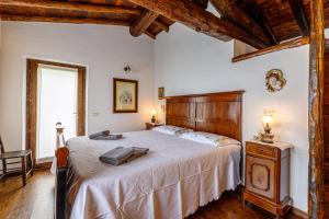 een slaapkamer met een groot bed met een houten hoofdeinde bij Villa Formaga - relax and view lake - Happy Rentals in Gargnano