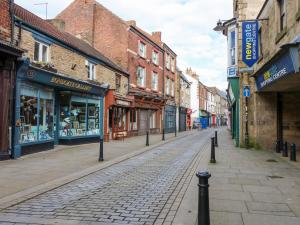 a cobblestone street in a city with buildings at The Old Assembly Rooms in Bishop Auckland