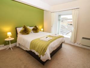 a bedroom with a bed with green walls and a window at The Old Assembly Rooms in Bishop Auckland