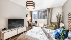 um quarto com uma televisão grande e uma cama em N20 Residence by Homenhancement em Genebra