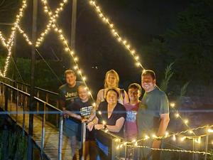 a group of people standing on a bridge with lights at Rose and Ivy Cottages in Louis Trichardt