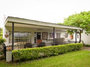 a house with a covered porch with a yard at Rose and Ivy Cottages in Louis Trichardt