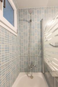 um chuveiro na casa de banho com paredes em azulejos azuis em Apartamento Himalaya em Sierra Nevada
