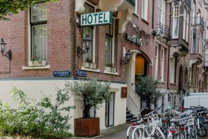 a row of bikes parked outside a hotel on a street at Hotel Fita in Amsterdam
