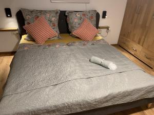 1 cama grande con edredón y almohadas grises en Mittendrin en Jesberg