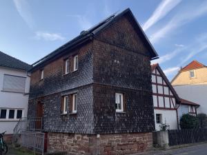 una antigua casa de ladrillo con techo negro en Mittendrin en Jesberg