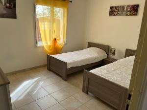 a bedroom with two beds and a window at Charmante maison entre mer et forêt in Saint-Hilaire-de-Riez