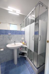 W łazience znajduje się umywalka i przeszklony prysznic. w obiekcie TerrasiniPalermoVacation Rentals w mieście Terrasini