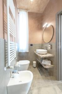 a bathroom with two sinks and a toilet and a mirror at Room Don Alfonso Luxury in Parma