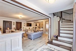 a large living room with a staircase and a tub at Casa Alexandru – Locul în care te simți acasă in Vişeu de Jos