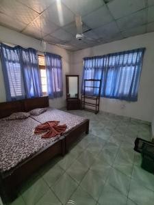 1 dormitorio con cama, espejo y ventanas en Hotel Mihira Village en Ambanpola