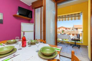 une salle à manger avec une table, des assiettes et des verres à vin dans l'établissement Magnolia Sirmione - Happy Rentals, à Sirmione