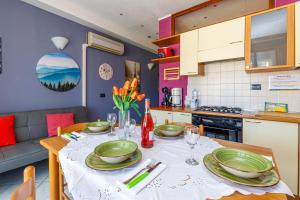 a kitchen and dining room with a table with plates on it at Magnolia Sirmione - Happy Rentals in Sirmione