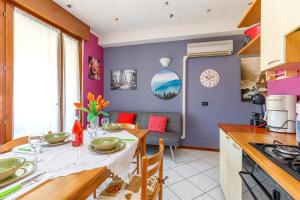 una cucina e una sala da pranzo con pareti viola e tavolo di Magnolia Sirmione - Happy Rentals a Sirmione