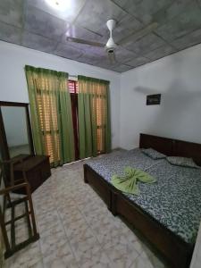 - une chambre avec un lit et une chaise dans l'établissement Hotel Mihira Village, à Ambanpola