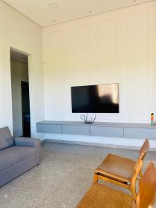 a living room with a couch and a tv at Casa de Campo Resort em Pardinho (Piscina c/ Borda Infinita) in Pardinho