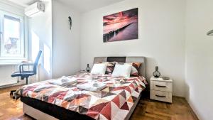 a bedroom with a bed with a quilt on it at Spacious & attractive 600m-7minuta hoda od centra, mogucnost za parking-apartmani-nsmilos in Novi Sad