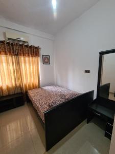 AmbanpolaにあるHotel Mihira Villageの小さなベッドルーム(ベッド1台、テレビ付)