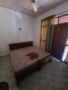 AmbanpolaにあるHotel Mihira Villageのカーテン付きの客室の小さなベッド1台分です。