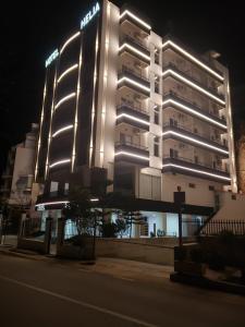 un gran edificio con luces en el lateral en Helia Hotel, en Sarandë